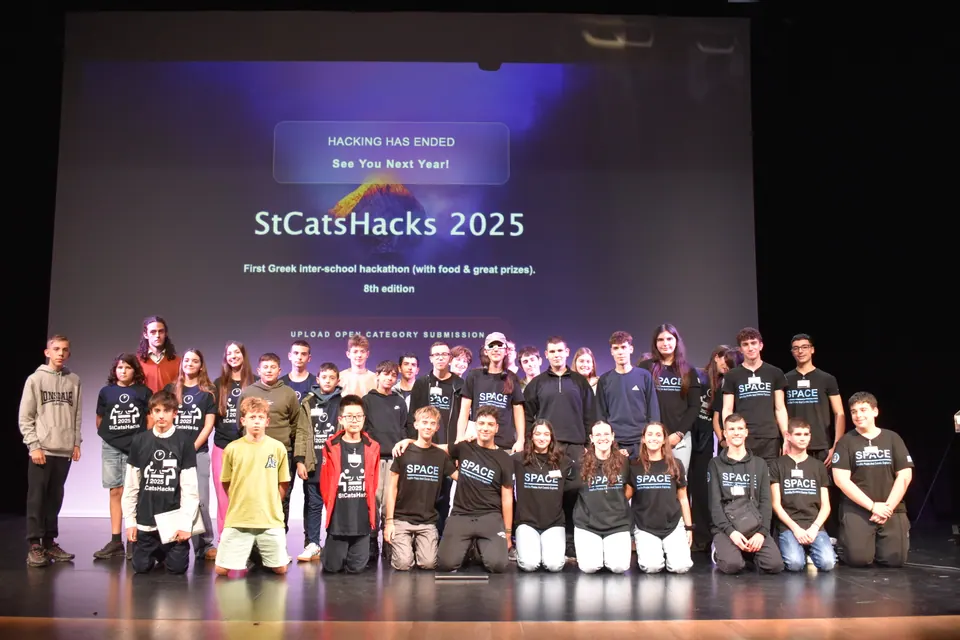 About forty students on stage under a screen reading StCatsHacks 2025, hacking has ended