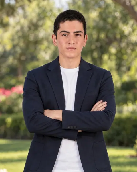 Vasilis Lavrentiadis in a navy blazer, arms crossed, outdoors